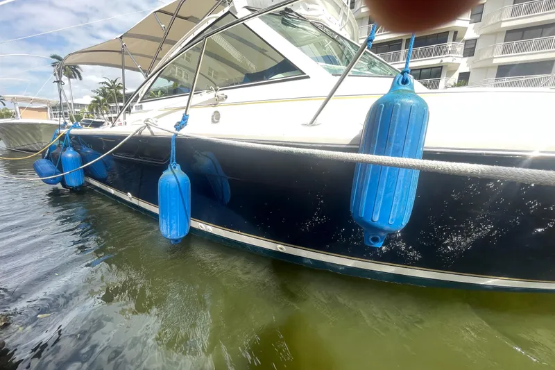 Slide: The Image of 2001 Tiara Yachts 2900 Coronet docked with blue fenders, sunny day, waterfront view. - 7