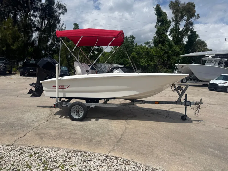 Slide: The Image of 2009 Boston Whaler 13 Sport boat with red canopy on trailer. - 1