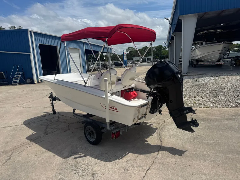 Slide: The Image of 2009 Boston Whaler 13 Sport boat with red canopy on trailer. - 3