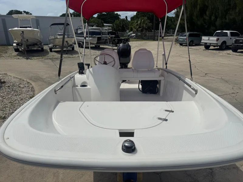 Slide: The Image of 2009 Boston Whaler 13 Sport boat with red sunshade. - 8