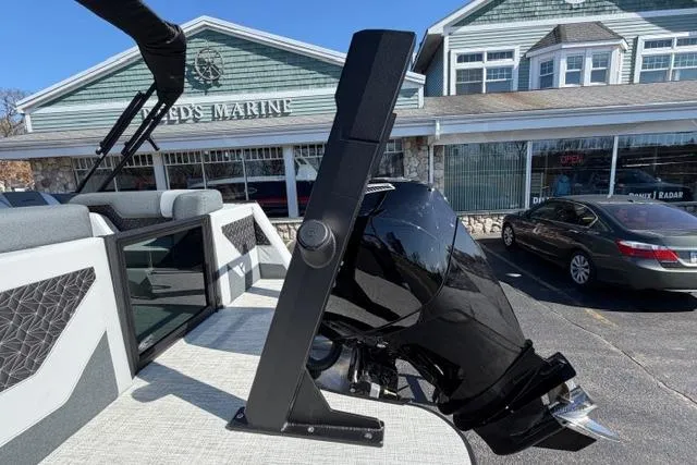 Slide: The Image of Alera M 23Q boat with sleek design, parked outside a marine store. - 10