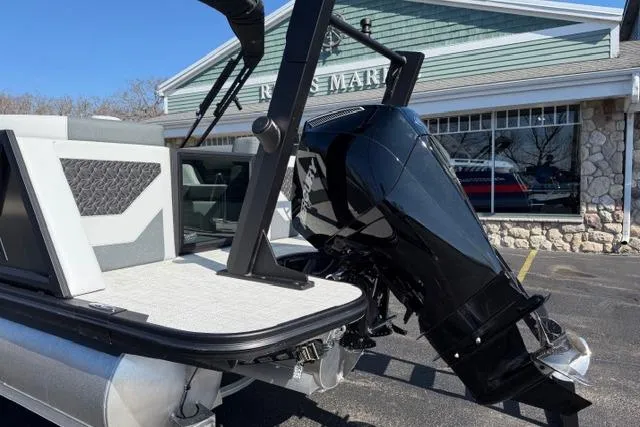 Slide: The Image of Alera M 23Q 2026 boat with powerful outboard motor, parked near a marine store. - 11