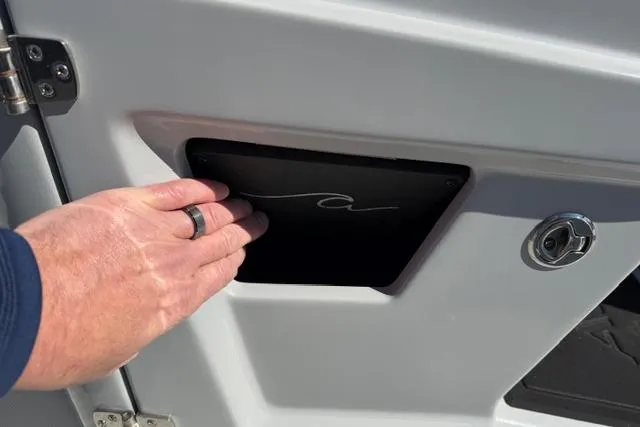 Slide: The Image of Hand opening compartment on 2026 Alera M 23Q boat. - 31