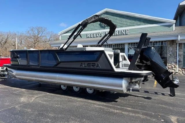Slide: The Image of 2026 Alera M 23Q pontoon boat parked outside Reeds Marine dealership. - 5