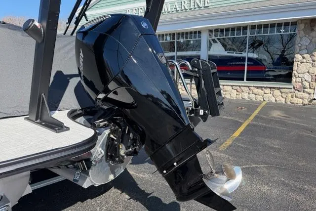 Slide: The Image of Alera M 23Q 2026 boat with a sleek black outboard motor in a marina setting. - 53