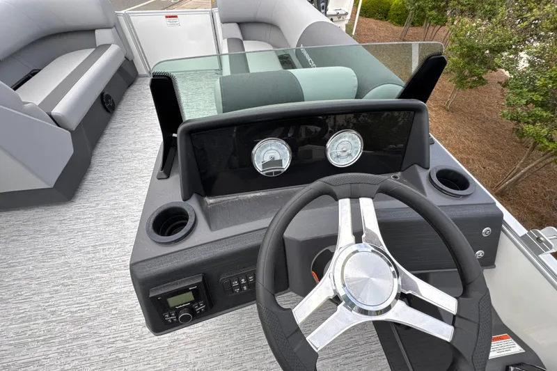 Slide: The Image of 2026 Bennington 22 SSB boat dashboard with steering wheel and seating area. - 11