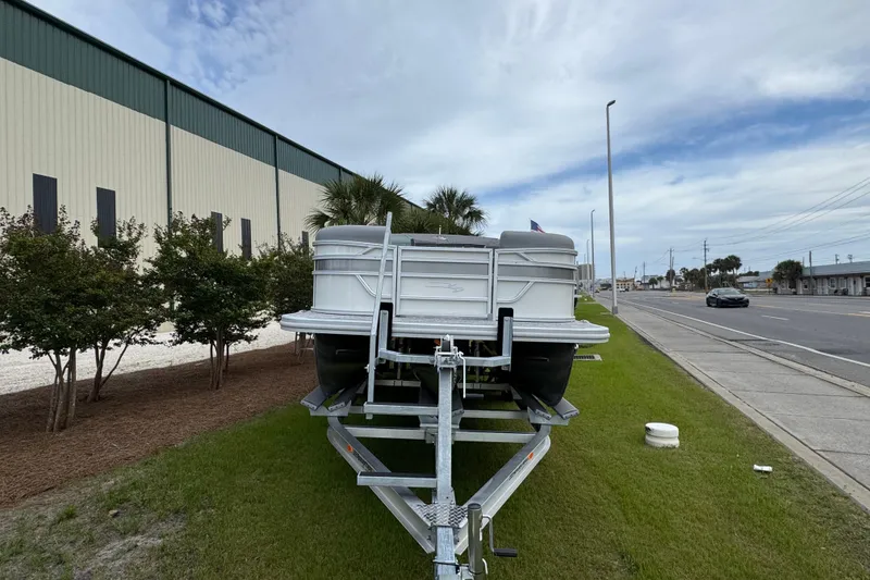 Slide: The Image of 2026 Bennington 22 SSB pontoon boat on trailer, parked beside a road. - 3
