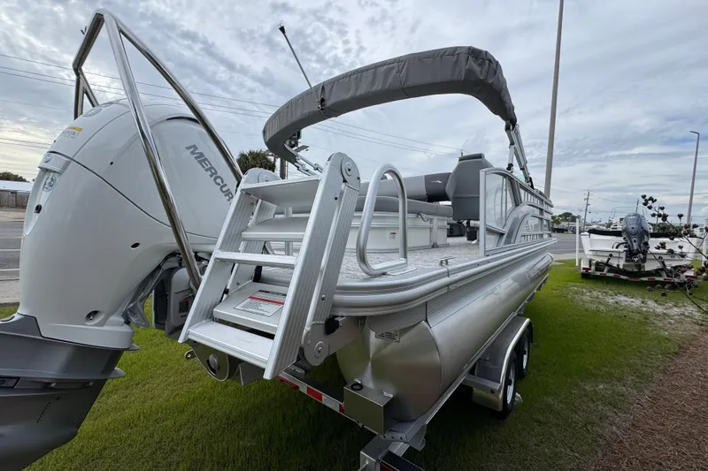 Slide: The Image of 2026 Bennington 22 SSB pontoon boat with Mercury engine, parked on grass. - 5