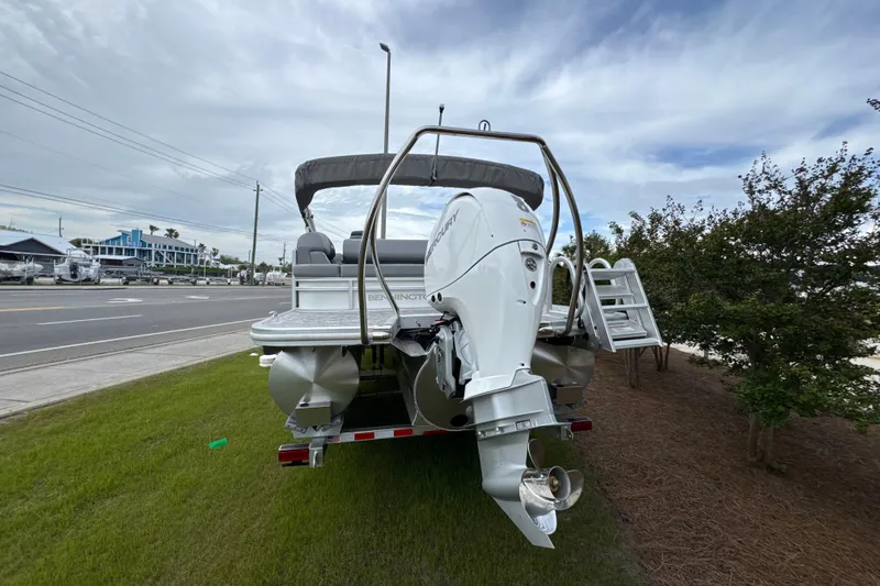 Slide: The Image of 2026 Bennington 22 SSB pontoon boat with Mercury outboard motor, parked on grass. - 6