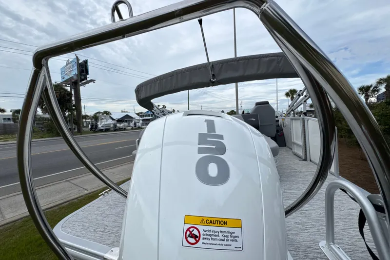 Slide: The Image of 2026 Bennington 22 SSB boat with 150 horsepower engine, docked near a road. - 7