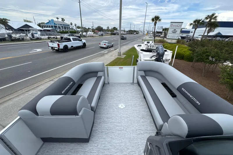 Slide: The Image of 2026 Bennington 22 SSB pontoon boat with gray seating, parked near a road. - 9