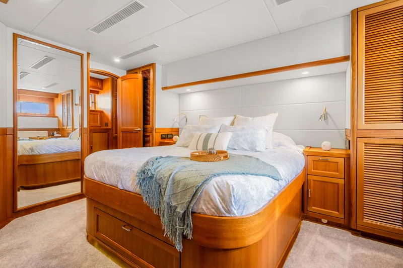 Slide: The Image of Luxurious 2023 Fleming 85 yacht bedroom with elegant wood finishes and cozy bedding. - 11