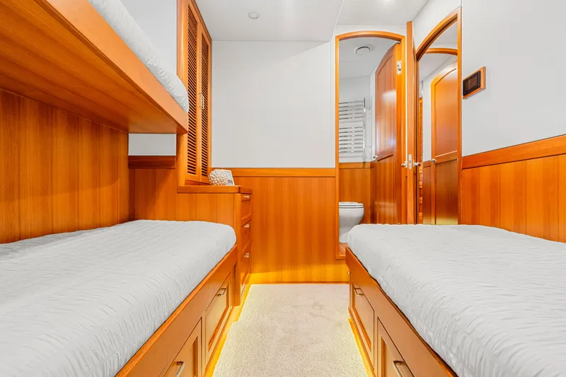 Slide: The Image of Luxurious 2023 Fleming 85 yacht cabin with twin beds and elegant wood paneling. - 21