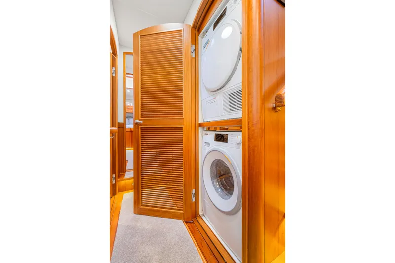 Slide: The Image of Laundry area with stacked washer and dryer in 2023 Fleming 85 yacht. - 25