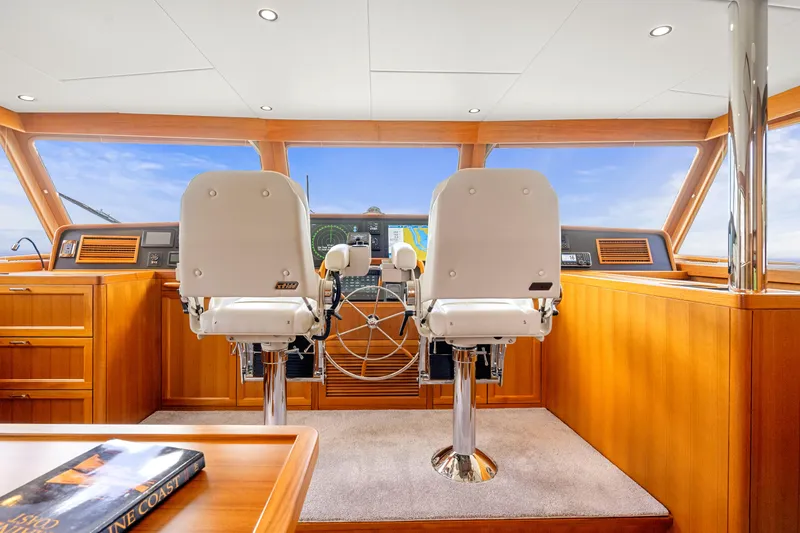 Slide: The Image of Pilothouse interior of 2023 Fleming 85 yacht with dual captain chairs and navigation equipment. - 34