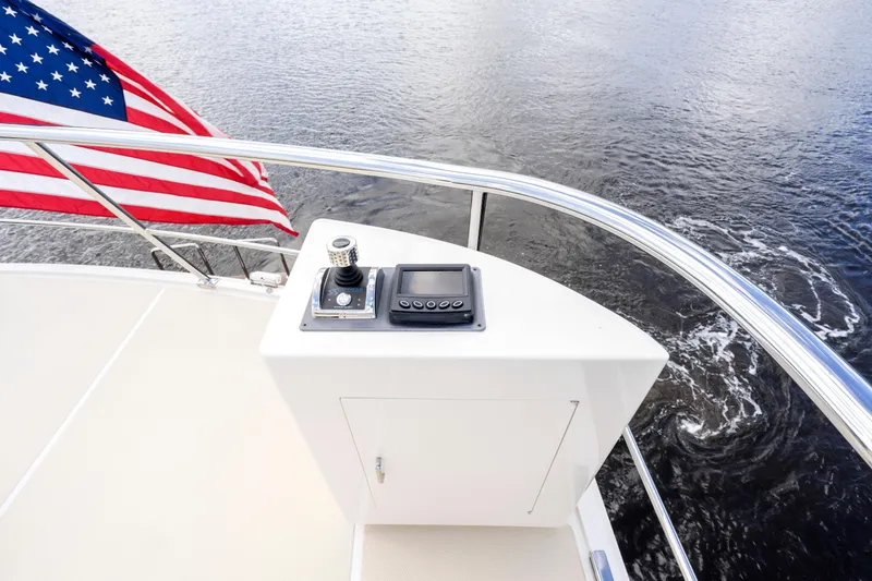 Slide: The Image of Control panel on 2023 Fleming 85 yacht with American flag, overlooking water. - 45
