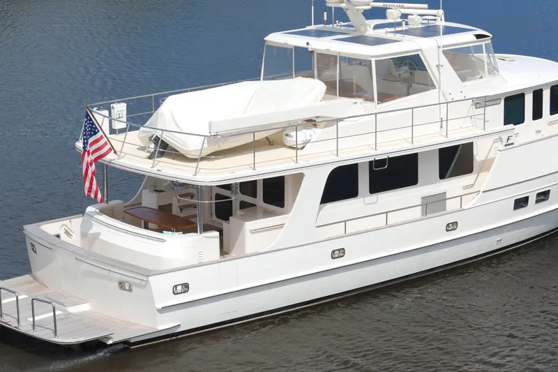 Slide: The Image of Luxurious 2023 Fleming 85 yacht on calm water, featuring sleek design and American flag. - 47