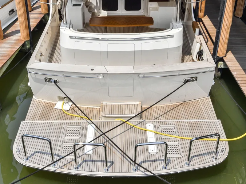 Slide: The Image of Stern view of 2023 Fleming 85 yacht docked with boarding platform and mooring lines. - 49