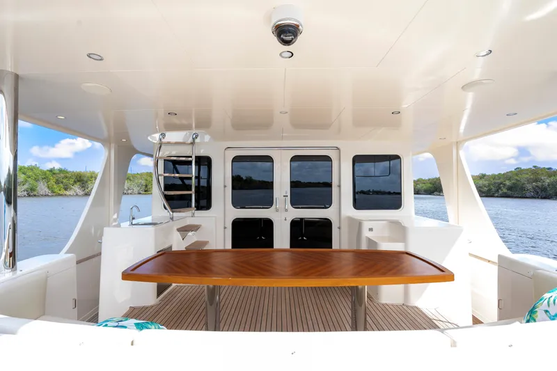 Slide: The Image of Luxurious 2023 Fleming 85 yacht interior with elegant wooden table and scenic water view. - 50