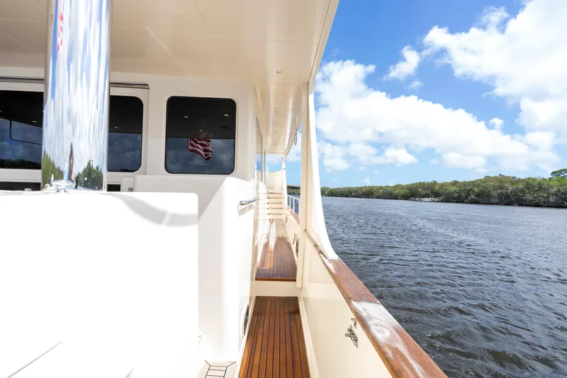 Slide: The Image of Side deck view of 2023 Fleming 85 yacht cruising on a scenic river. - 54