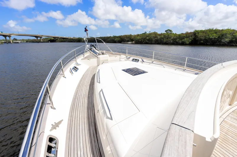 Slide: The Image of Luxurious 2023 Fleming 85 yacht cruising on a scenic river under a blue sky. - 57