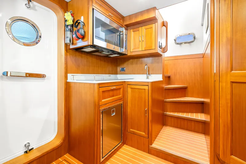 Slide: The Image of Luxurious wooden interior of 2023 Fleming 85 yacht with kitchenette and stairs. - 64
