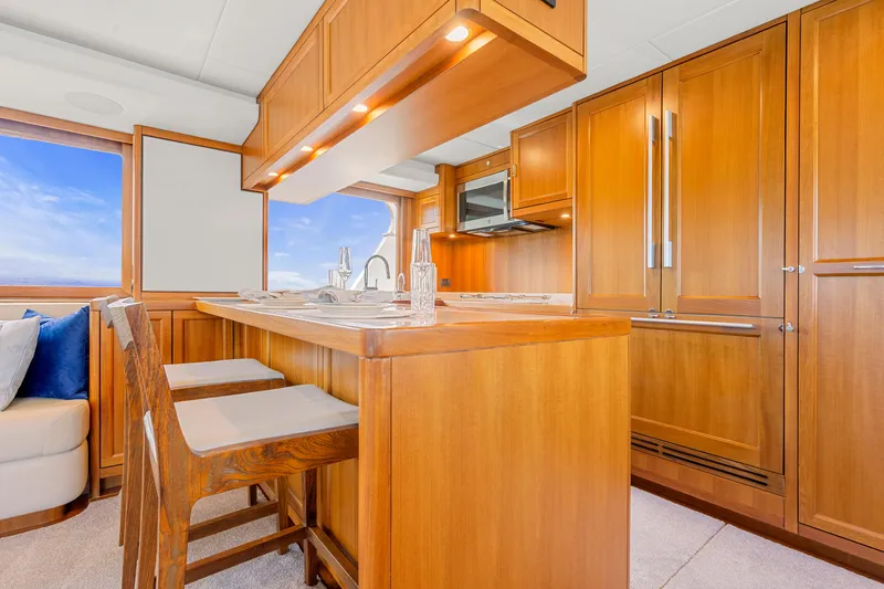 Slide: The Image of Luxurious wooden kitchen interior on a 2023 Fleming 85 yacht, featuring modern appliances. - 7