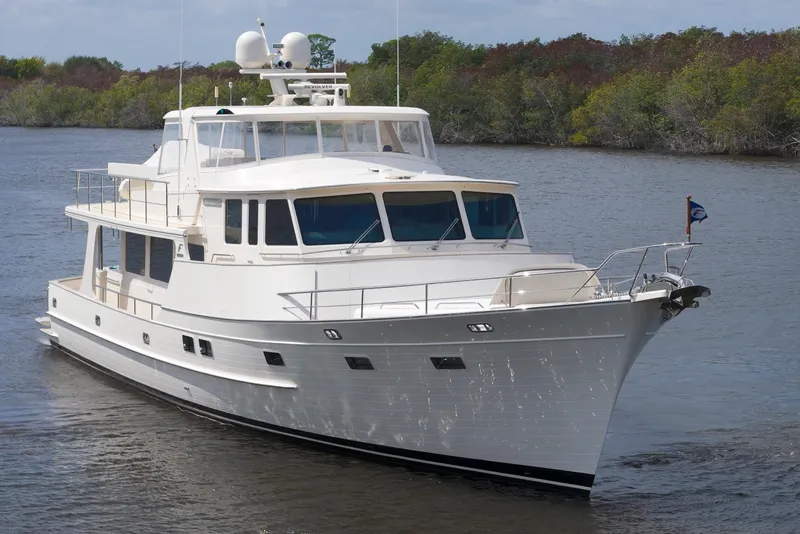 Slide: The Image of Luxurious 2023 Fleming 85 yacht cruising on a serene river, surrounded by lush greenery. - 79