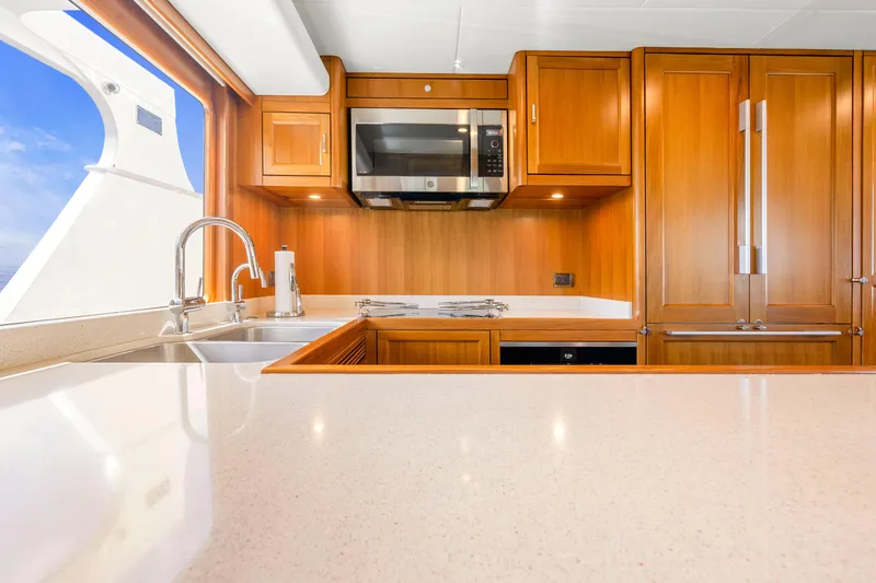 Slide: The Image of Luxurious kitchen interior on 2023 Fleming 85 yacht, featuring wood cabinetry and modern appliances. - 8