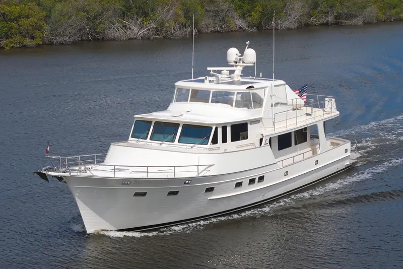 Slide: The Image of Luxury 2023 Fleming 85 yacht cruising on a serene waterway. - 83