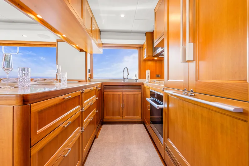 Slide: The Image of Luxurious wooden kitchen interior on a 2023 Fleming 85 yacht, featuring modern appliances. - 9