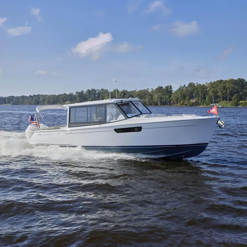 Slide: The Image of 2026 MJM 38x boat cruising on a lake under a clear blue sky. - 22