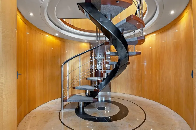 Slide: The Image of Luxurious spiral staircase inside 2005 New Zealand Yachts 115 Wave Piercer, featuring elegant wood paneling. - 38