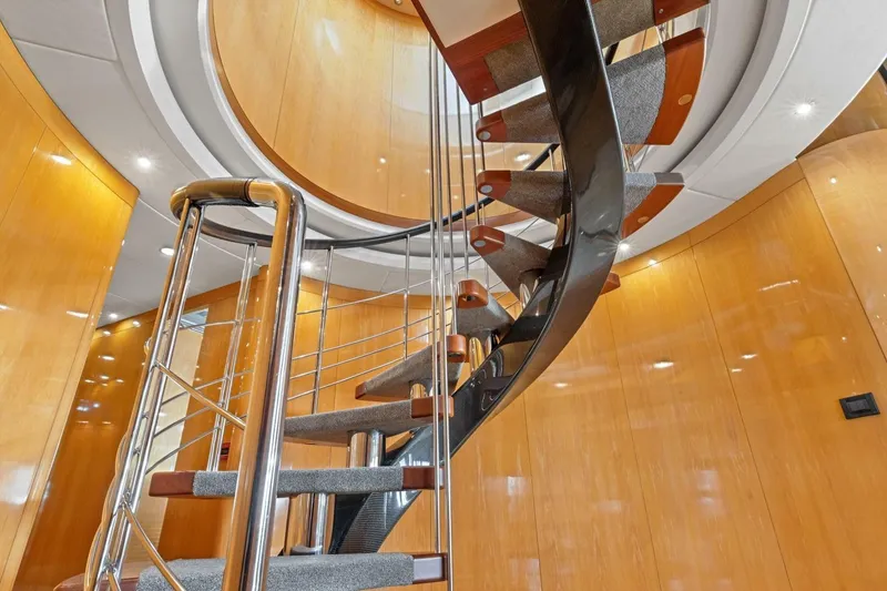 Slide: The Image of Spiral staircase inside 2005 New Zealand Yachts 115 Wave Piercer, featuring sleek wood and metal design. - 39