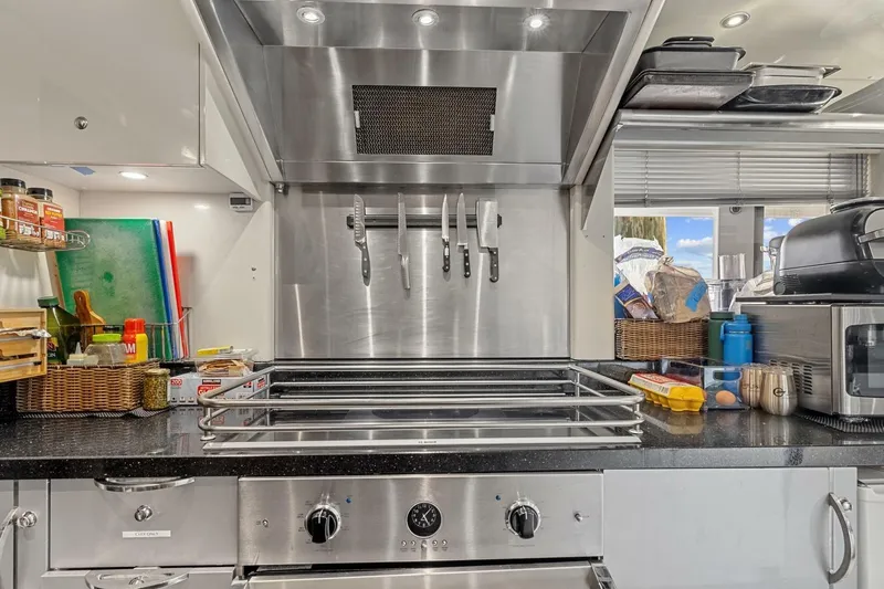 Slide: The Image of Modern yacht kitchen with stainless steel appliances, knife rack, and organized countertop essentials. - 60
