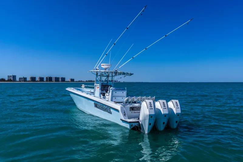 Slide: The Image of 2003 Contender 36 Open boat with four engines on blue ocean water. - 10
