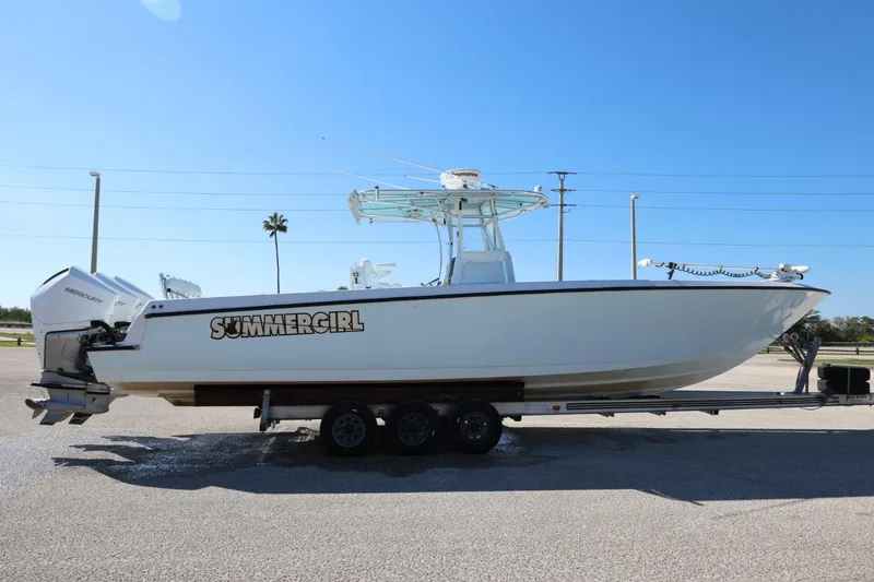 Slide: The Image of 2003 Contender 36 Open boat on trailer, labeled "SUMMERGIRL," under clear blue sky. - 11