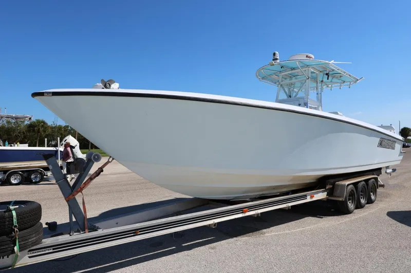 Slide: The Image of 2003 Contender 36 Open boat on trailer under clear blue sky. - 13