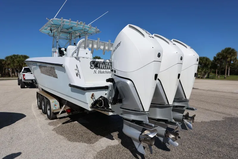 Slide: The Image of 2003 Contender 36 Open boat with triple outboard engines on a trailer. - 14