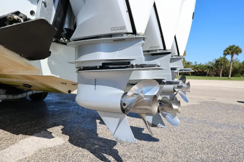 Slide: The Image of Triple outboard motors on a 2003 Contender 36 Open boat, parked on pavement. - 15