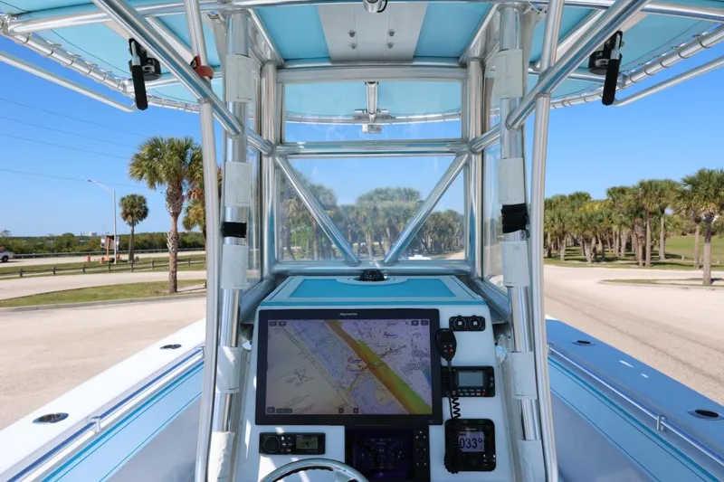 Slide: The Image of 2003 Contender 36 Open boat cockpit with navigation system, palm trees in background. - 18