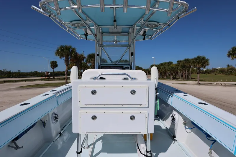 Slide: The Image of 2003 Contender 36 Open boat interior with storage drawers and T-top, parked outdoors. - 23