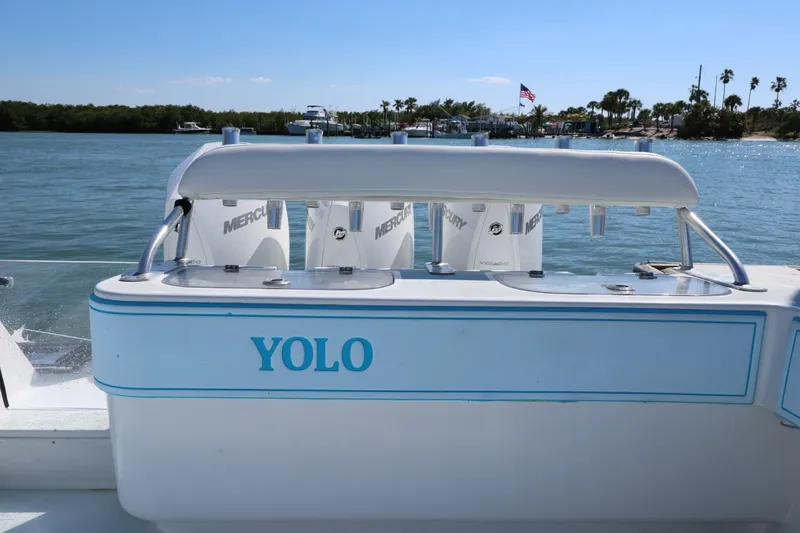 Slide: The Image of 2003 Contender 36 Open boat named "YOLO" with Mercury engines on a sunny day. - 24