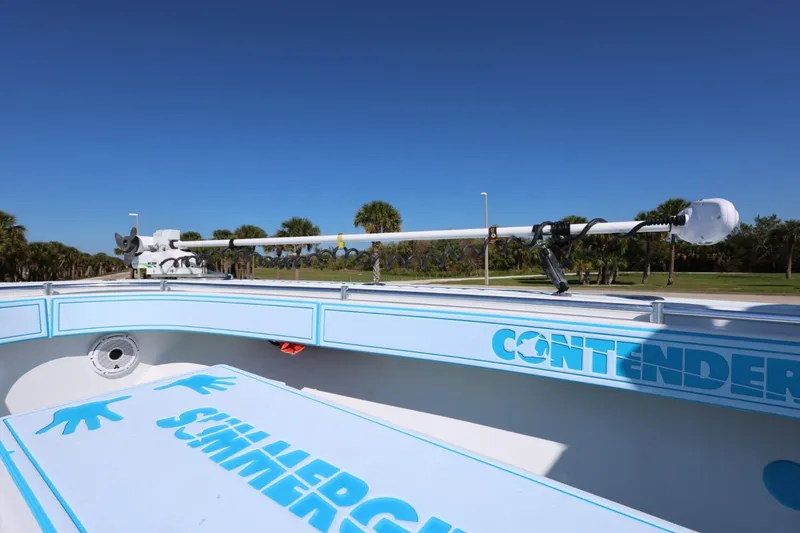 Slide: The Image of 2003 Contender 36 Open boat with blue accents and trolling motor, under clear blue sky. - 28
