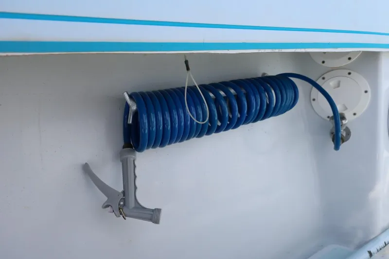 Slide: The Image of Coiled blue hose with spray nozzle on 2003 Contender 36 Open boat. - 34