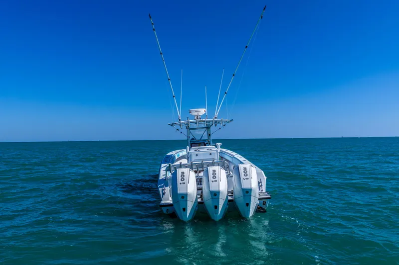 Slide: The Image of 2003 Contender 36 Open boat with triple engines on open sea under clear blue sky. - 4