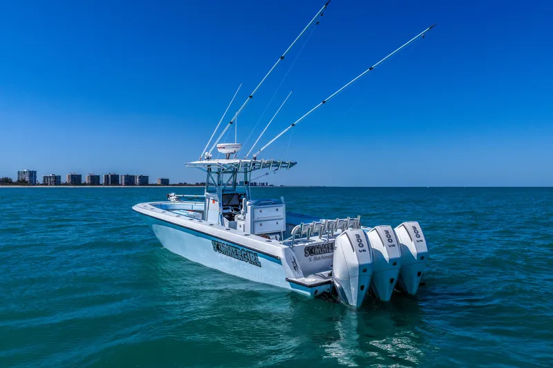 Slide: The Image of 2003 Contender 36 Open boat with triple engines on blue ocean, clear sky background. - 47