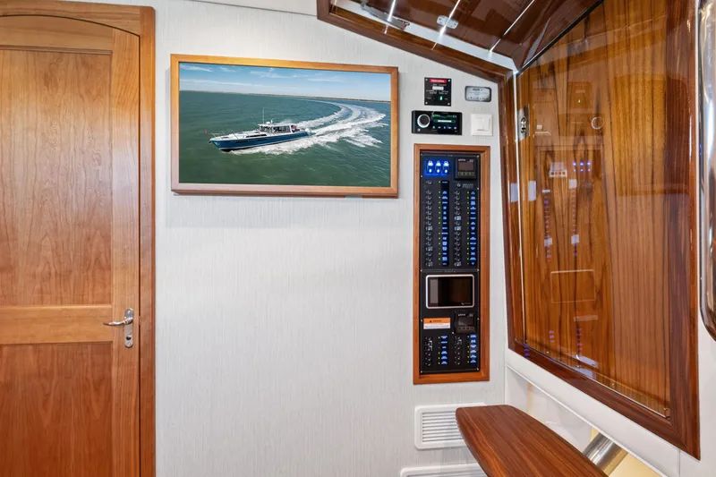 Slide: The Image of Interior of a 2026 MJM 47 R yacht with control panel and framed boat photo. - 17