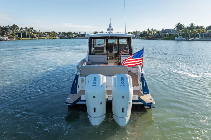 Slide: The Image of 2026 MJM 47 R boat with dual 600 V12 engines on a sunny waterway. - 2