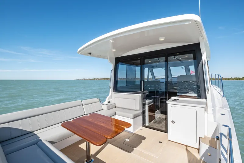 Slide: The Image of Luxury MJM 47 R yacht deck with seating and table, cruising on open water, 2026 model. - 34